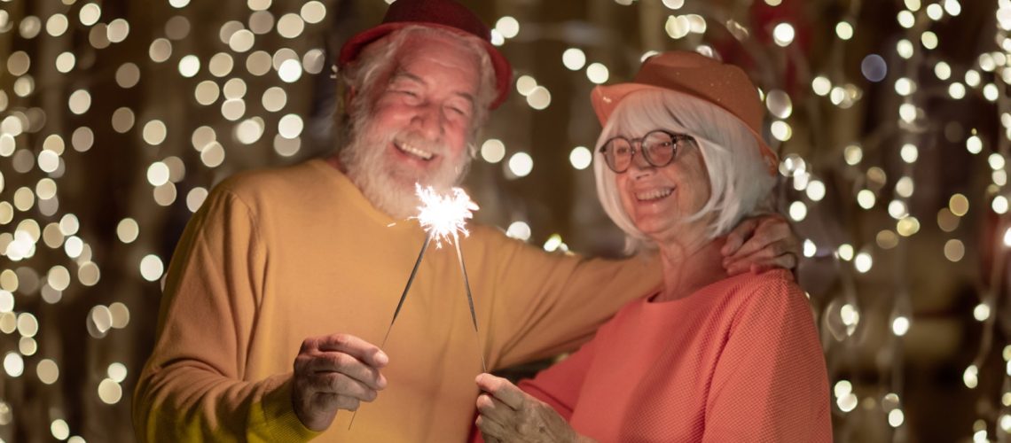 Blurred,Caucasian,Senior,Couple,Holding,Sparklers,Celebrating,New,Year.,Happy